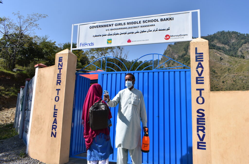 A student's temperature is taken before entering the school grounds.